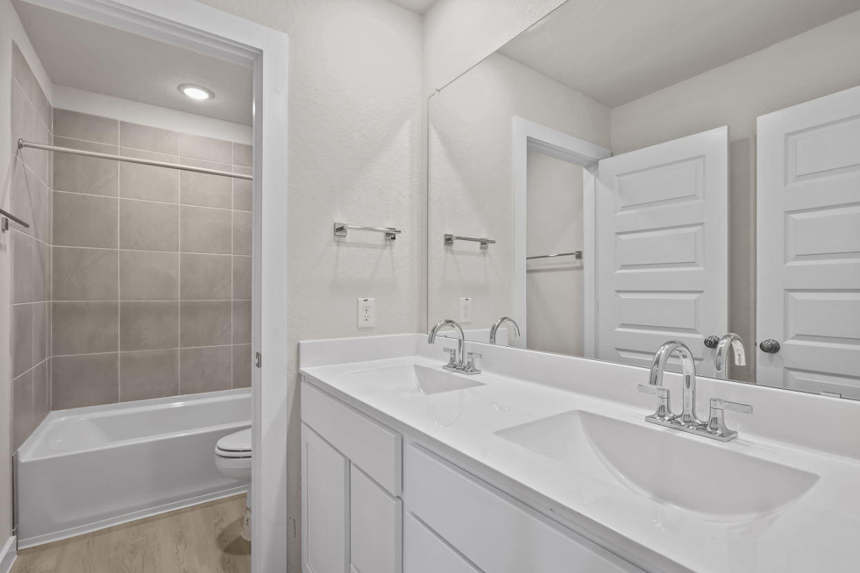 A bathroom with a tub sink and a toilet.