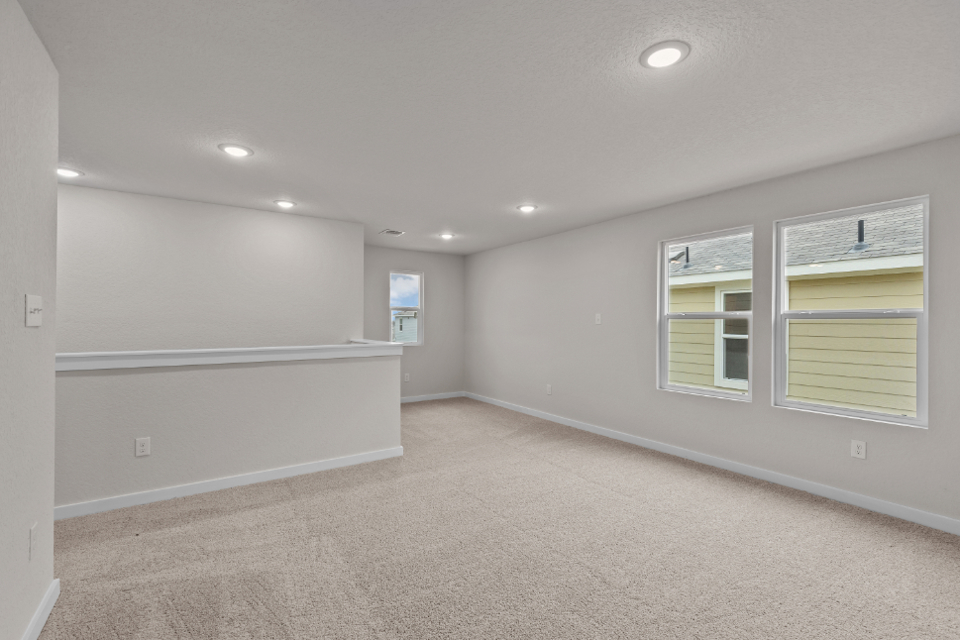 A room with a white wall and windows.
