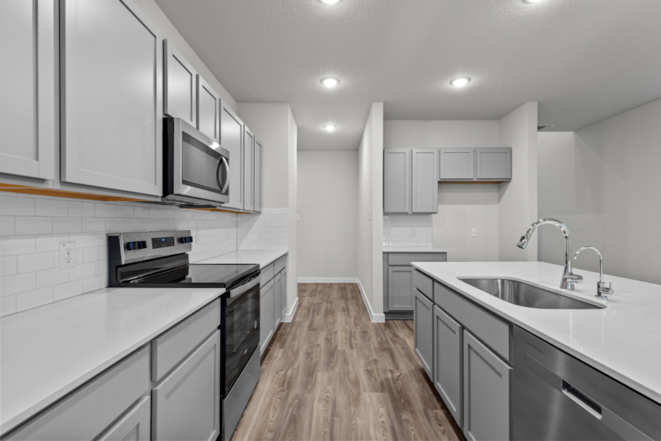 A kitchen with white cabinets.