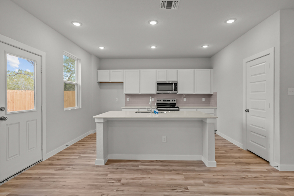 A kitchen with white cabinets.
