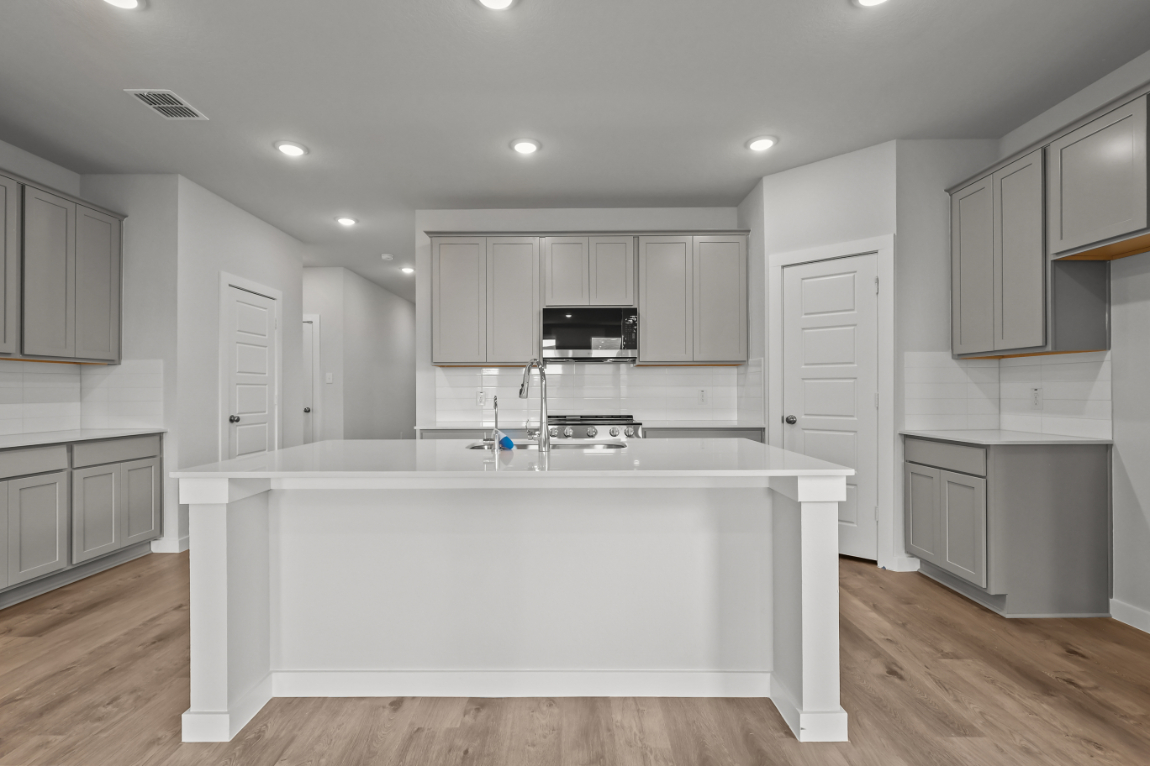 A kitchen with white cabinets.