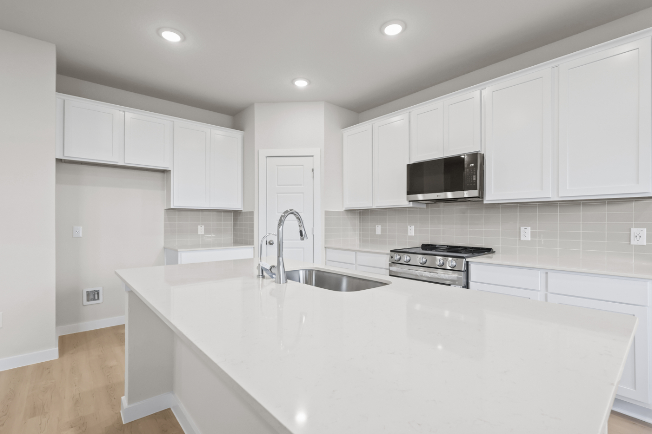 A kitchen with white cabinets.