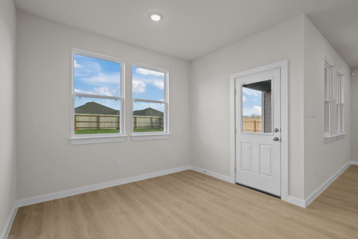 A room with a wood floor and a white door with a window.