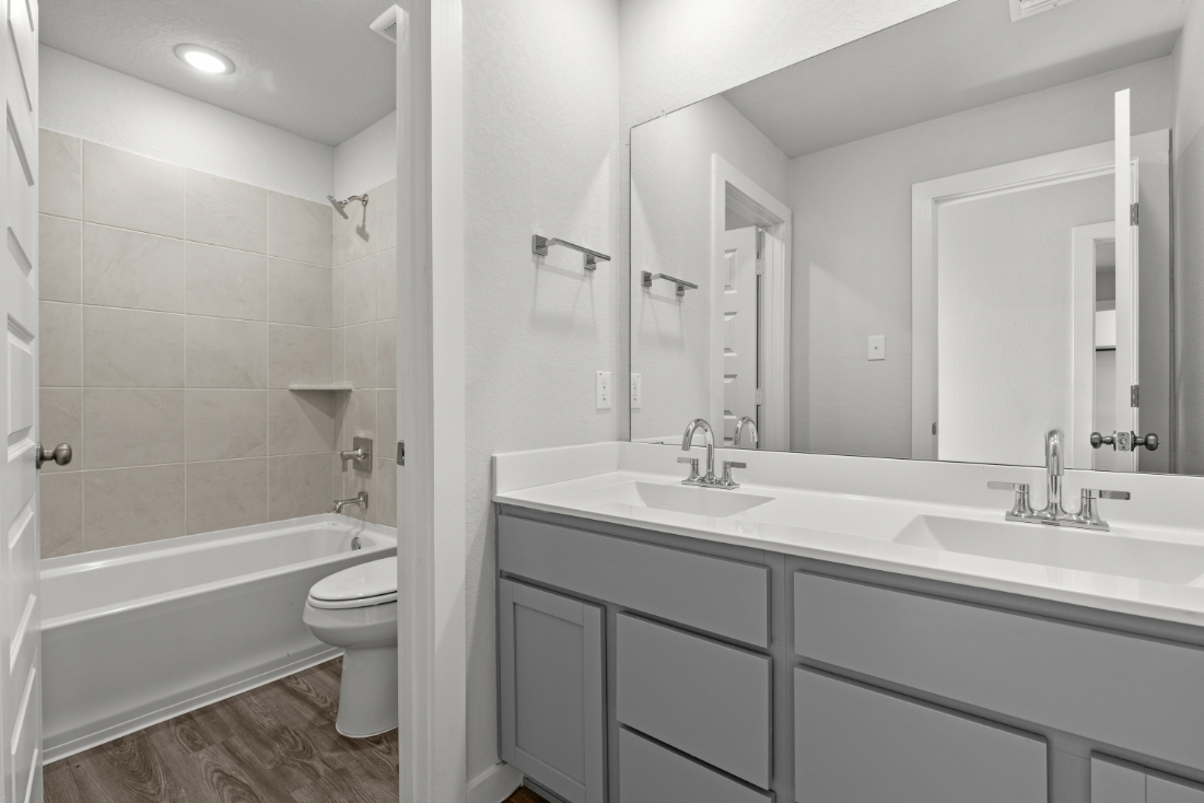 A bathroom with a tub sink and toilet.