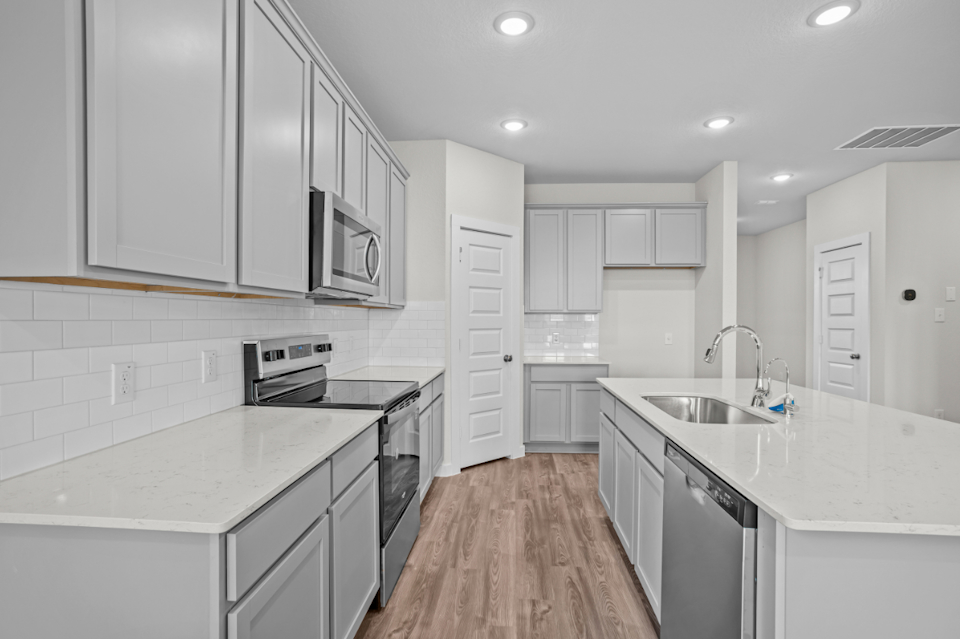 A kitchen with white cabinets.