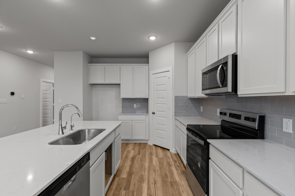 A kitchen with white cabinets.