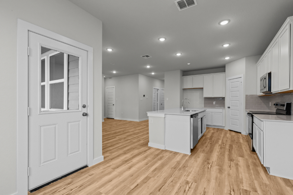 A kitchen with white cabinets.