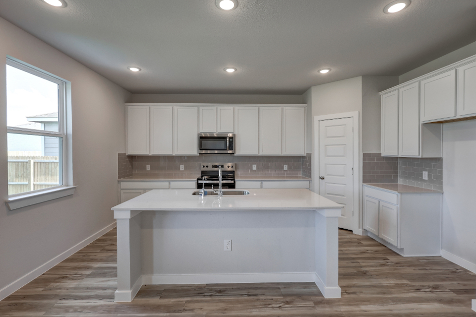 A kitchen with white cabinets.
