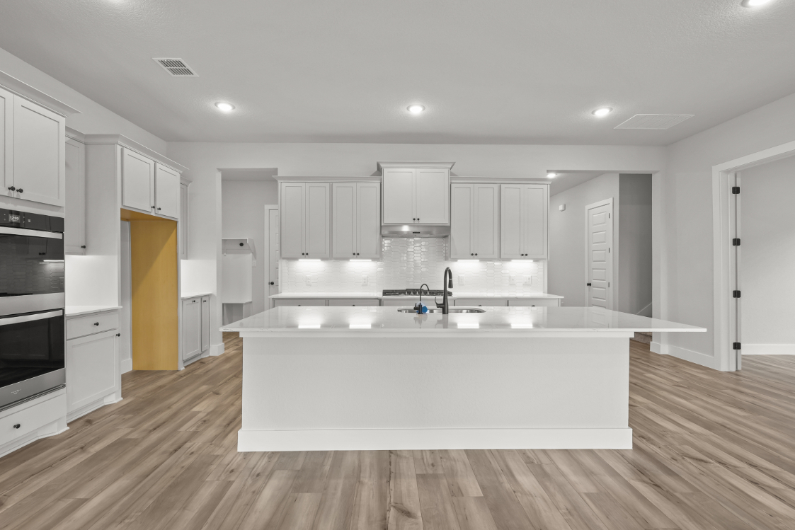 A kitchen with white cabinets.