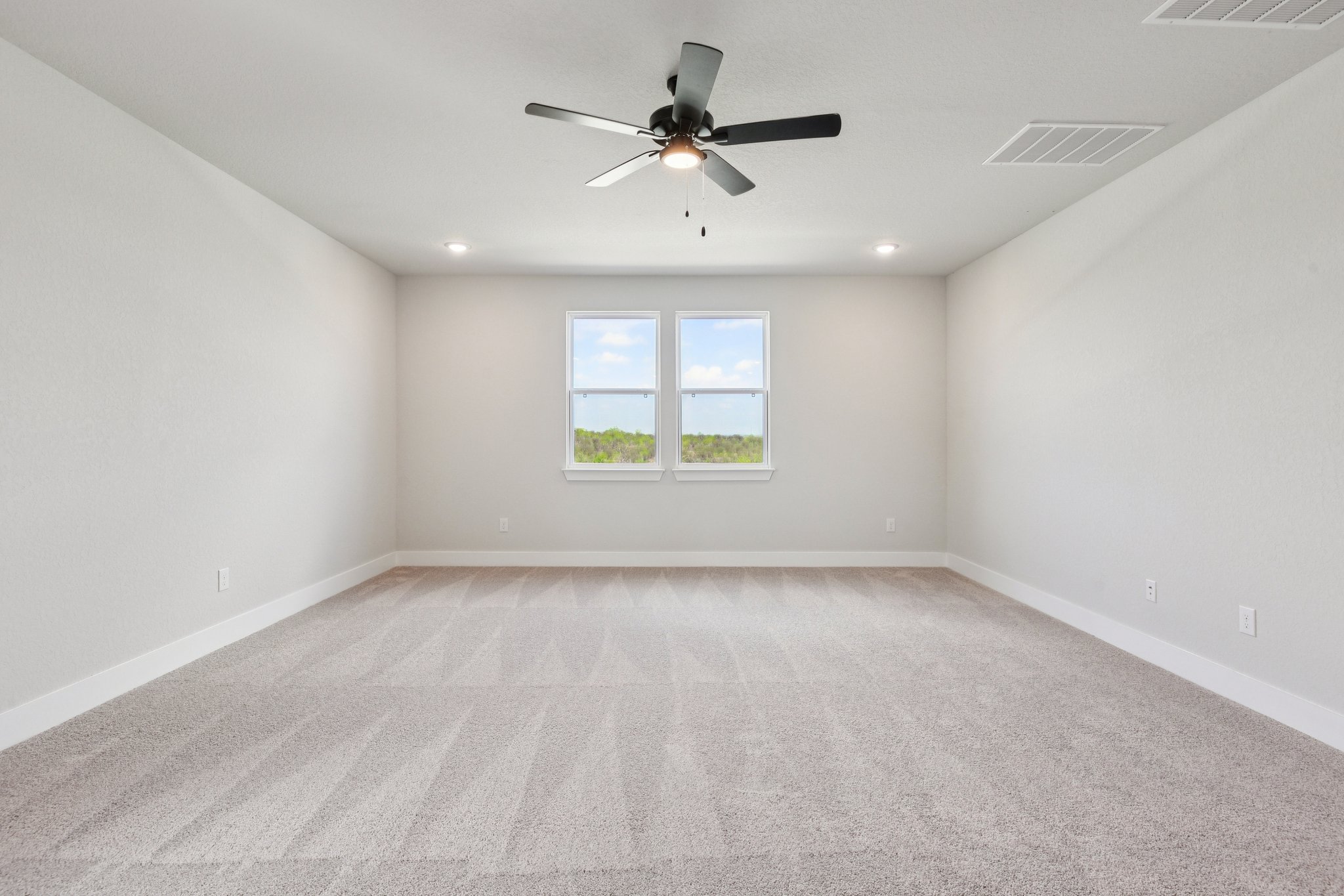 A room with a ceiling fan and a window.