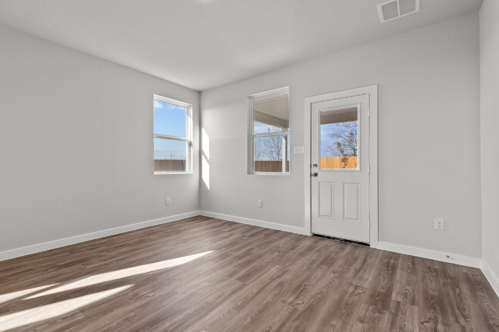 A room with white walls and a wood floor.