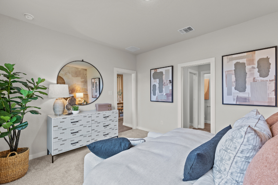 A bedroom with a bed and a mirror.