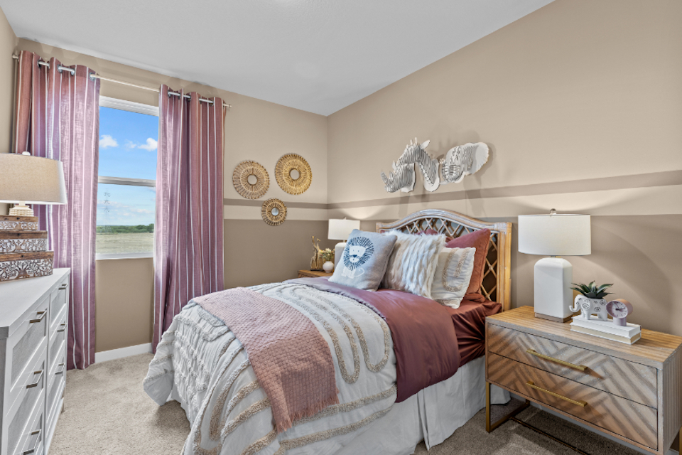 A bedroom with pink curtains.