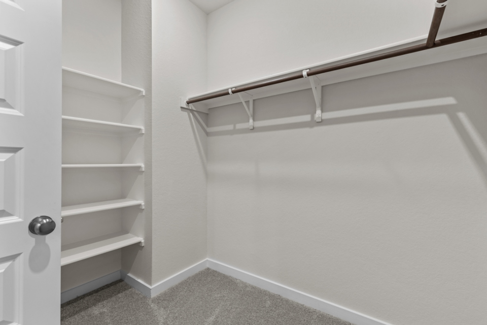 A white wall with a metal bar.
