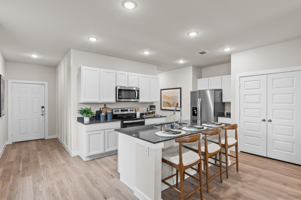 A kitchen with white cabinets.