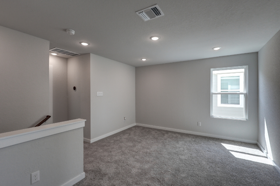 A room with a white wall and a window.