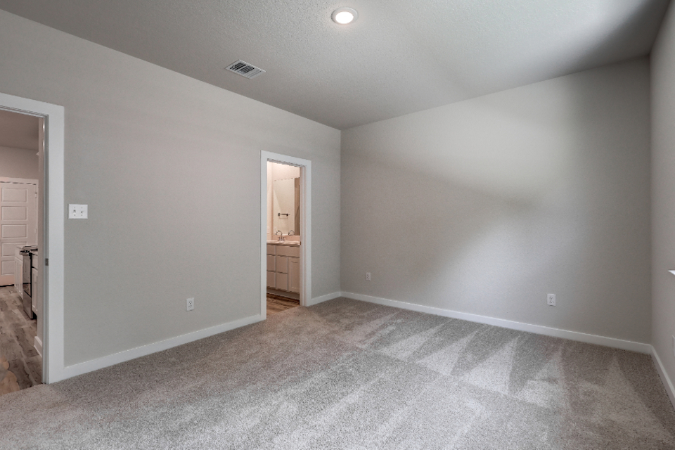A room with a carpet and a door.