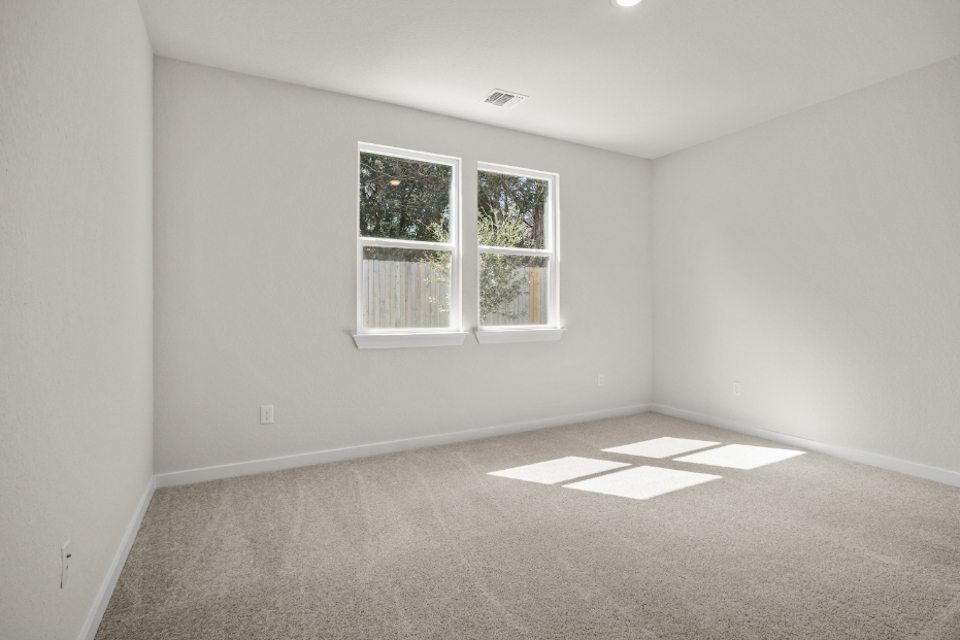 A room with a window and a rug.