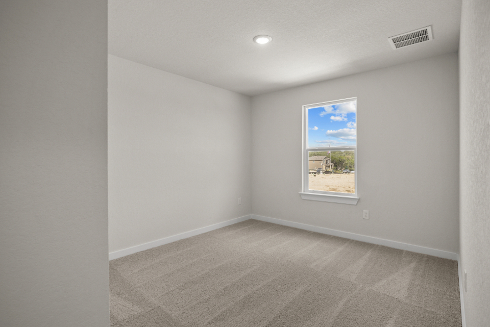 A room with a window and a rug.