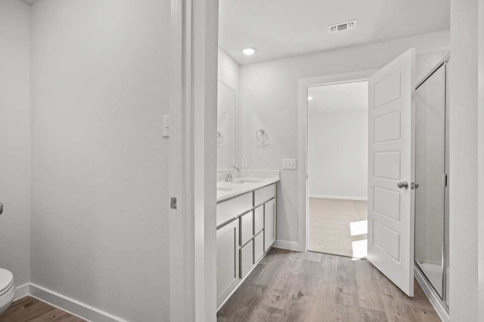 A bathroom with white cabinets.
