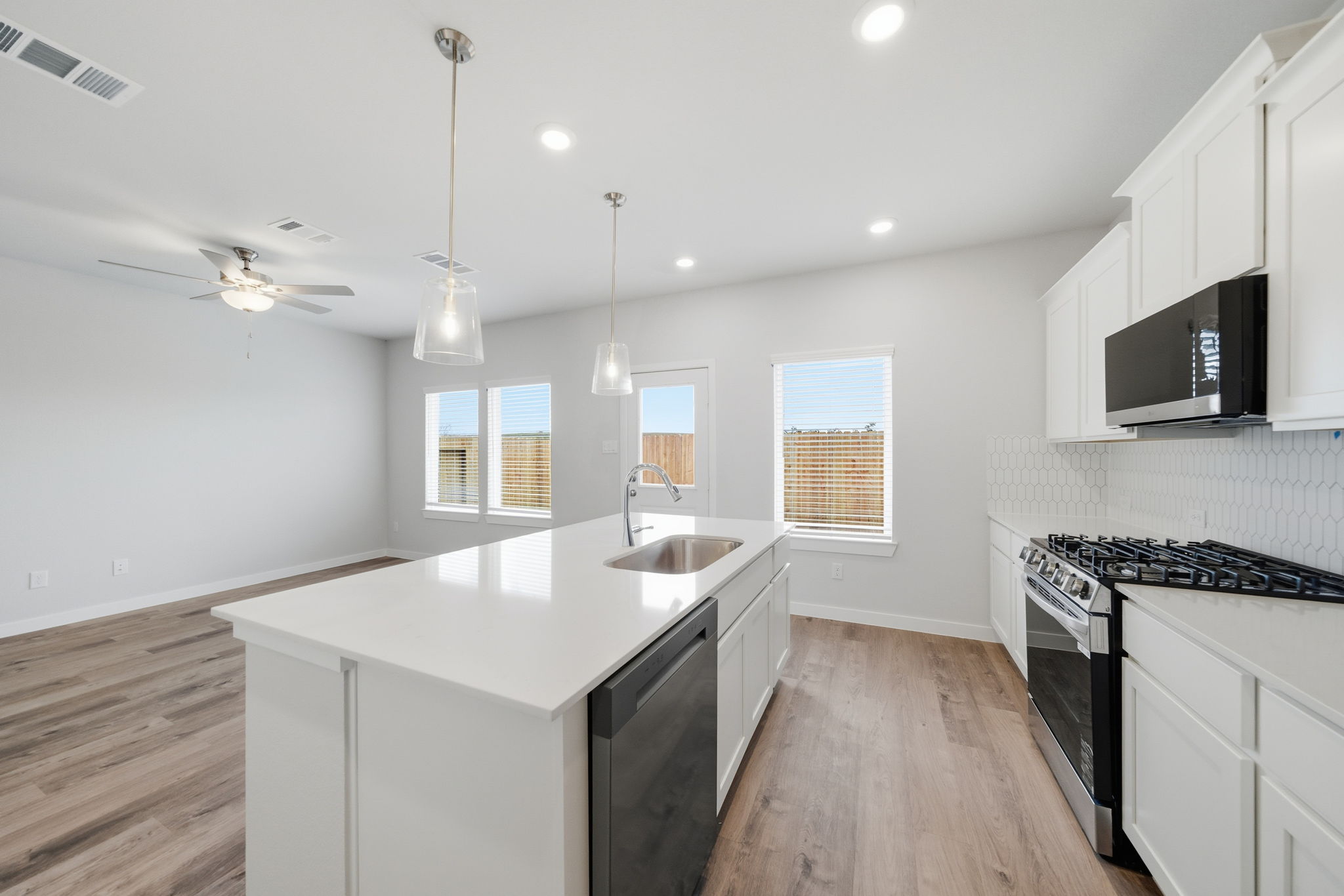 A kitchen with white cabinets.