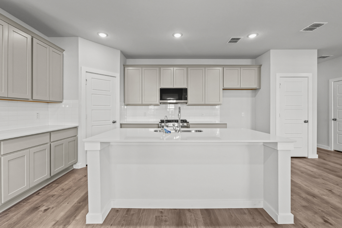 A kitchen with white cabinets.