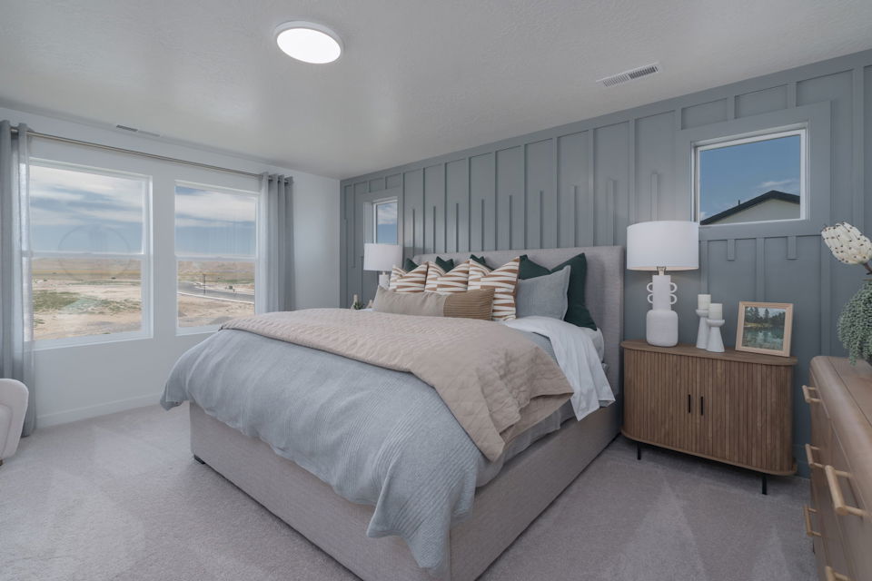 A bedroom with a bed and a lamp.