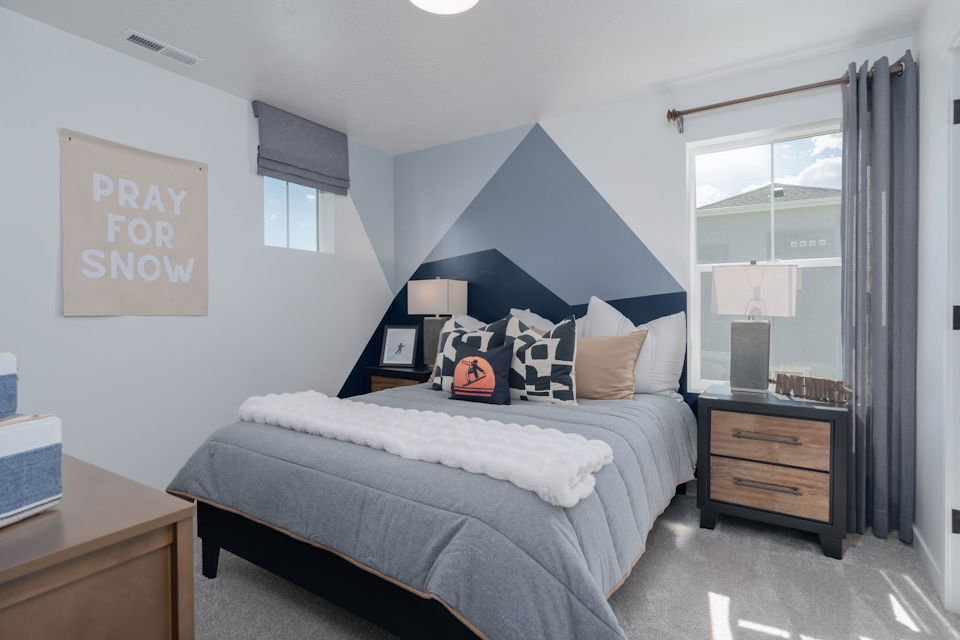 A bedroom with a bed and a desk.