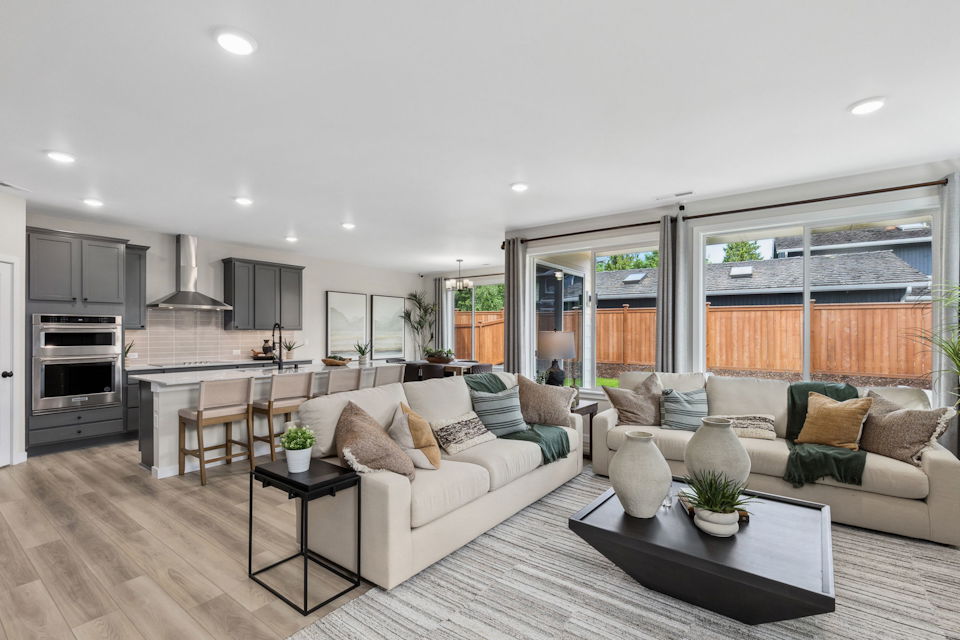 A large living room with a large kitchen and a large window.