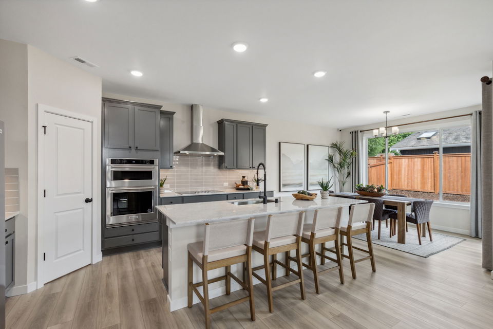 A kitchen with a dining table and chairs.