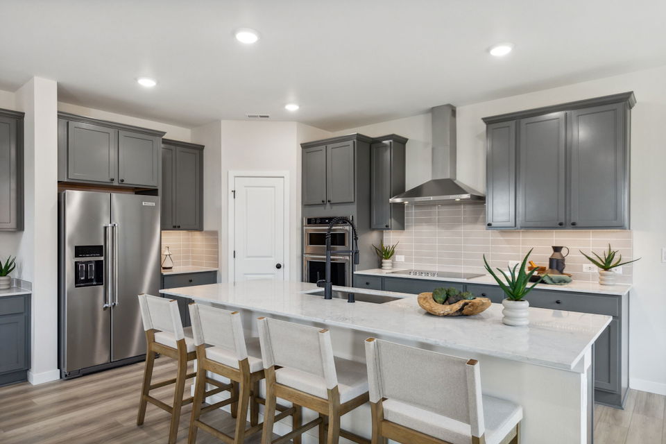 A kitchen with a dining table and chairs.