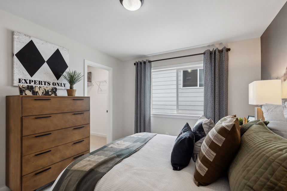 A bedroom with a bed and a dresser.