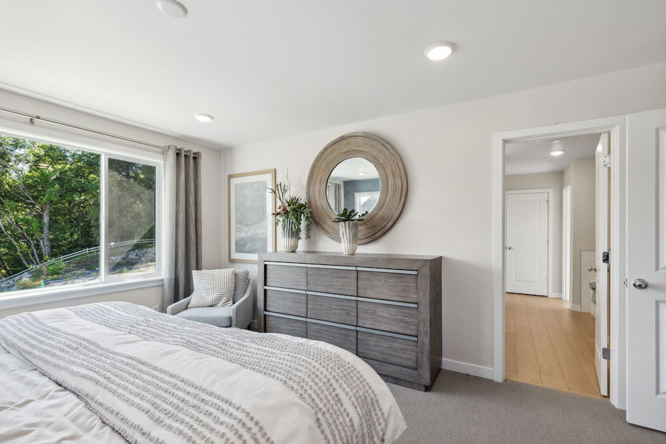 A bedroom with a bed and a mirror.