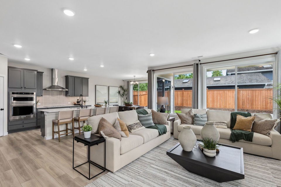 A large living room with a large kitchen and a large window.