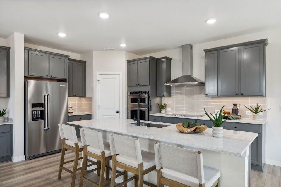 A kitchen with a dining table and chairs.
