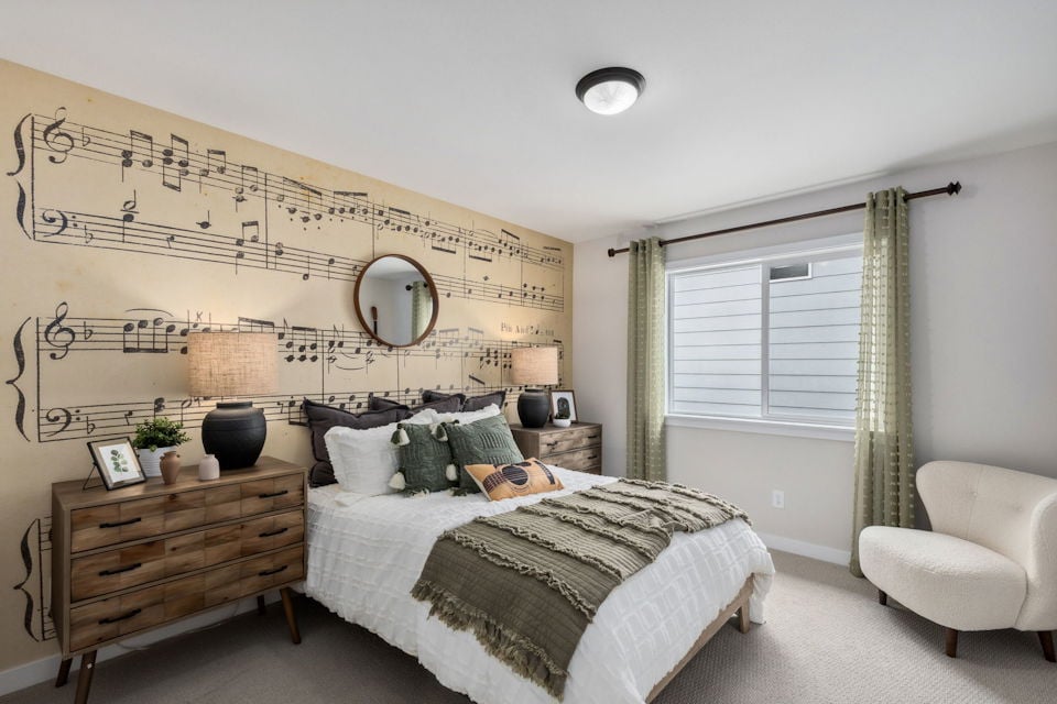 A bedroom with a bed and a chair.