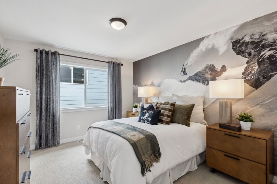 A bedroom with a bed and a lamp.