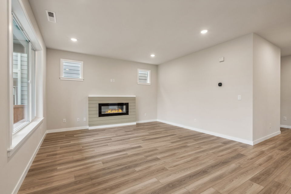 A room with a fireplace and a wood floor.