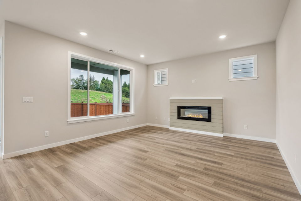 A room with a fireplace and a wood floor.