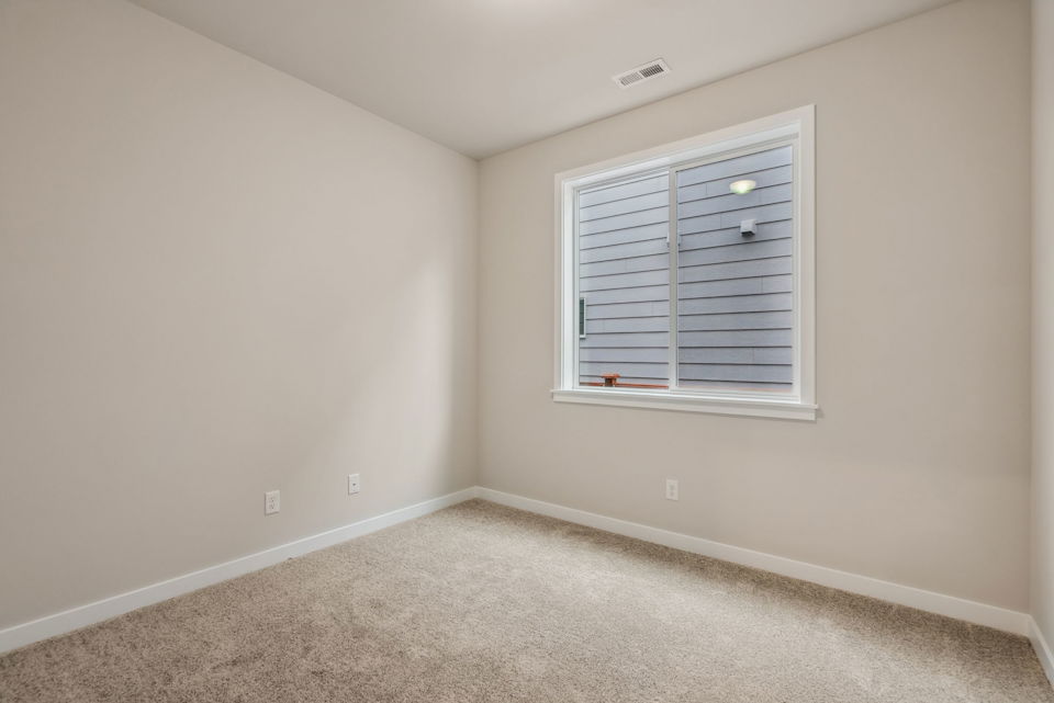A room with a window and carpet.
