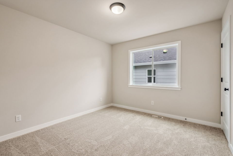 A room with a window and a carpet.
