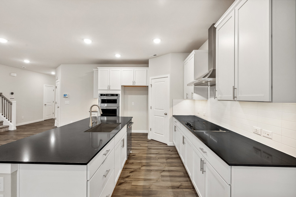 A kitchen with white cabinets.