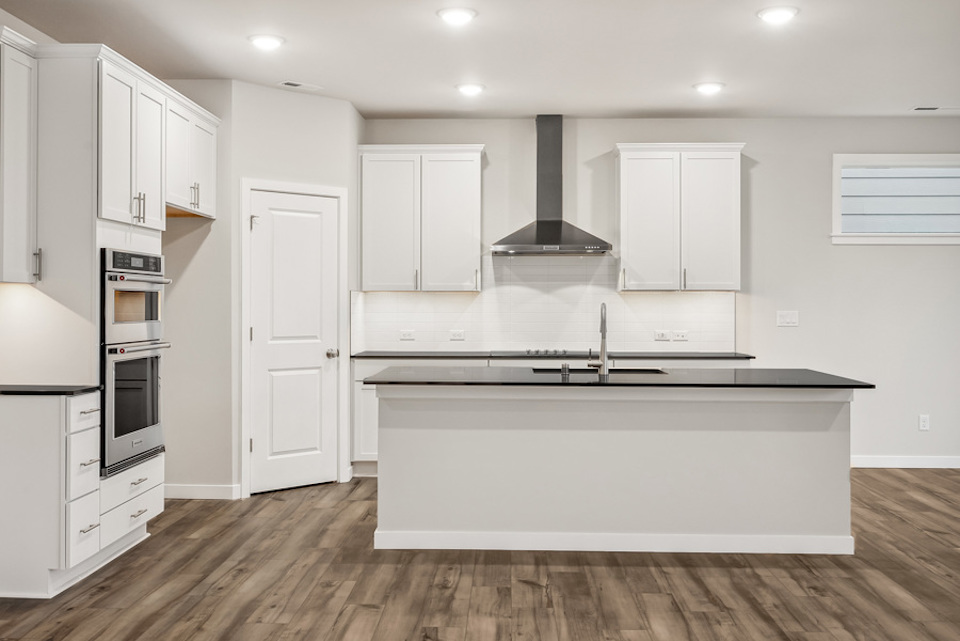 A kitchen with white cabinets.
