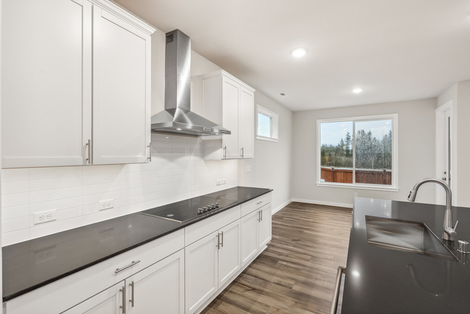 A kitchen with white cabinets.