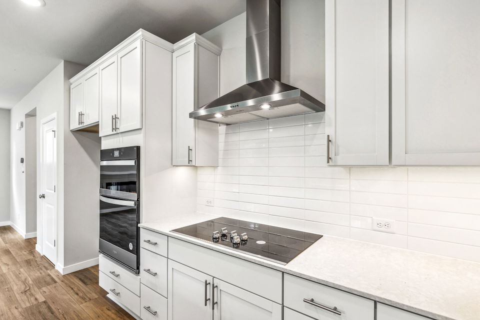 A kitchen with white cabinets.