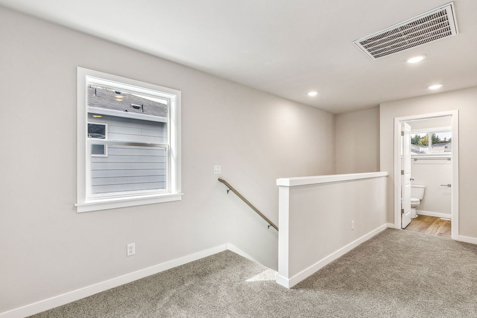 A white room with a bathtub and a window.