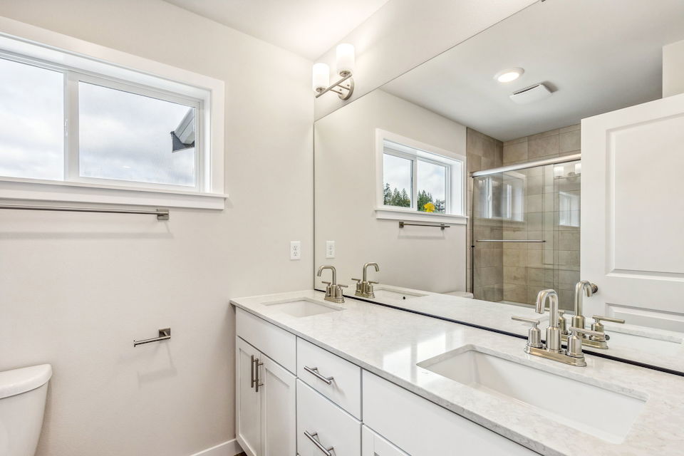 A bathroom with a large mirror.