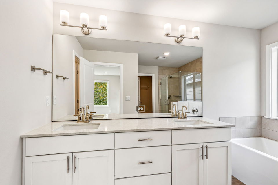A bathroom with a large mirror.