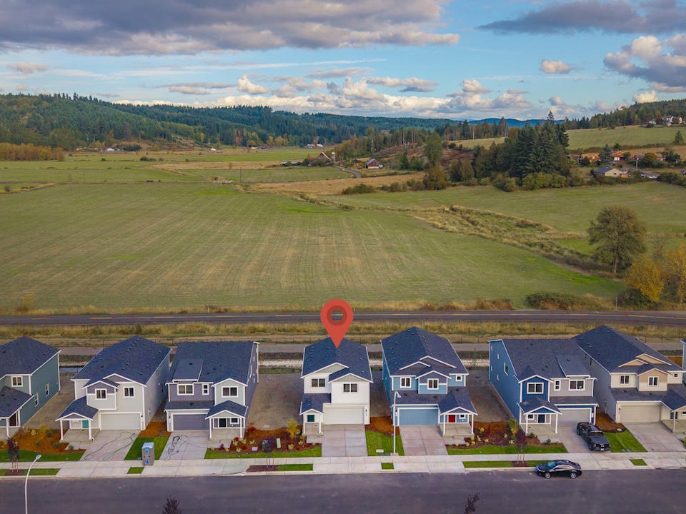 A group of houses with a large field in the background.