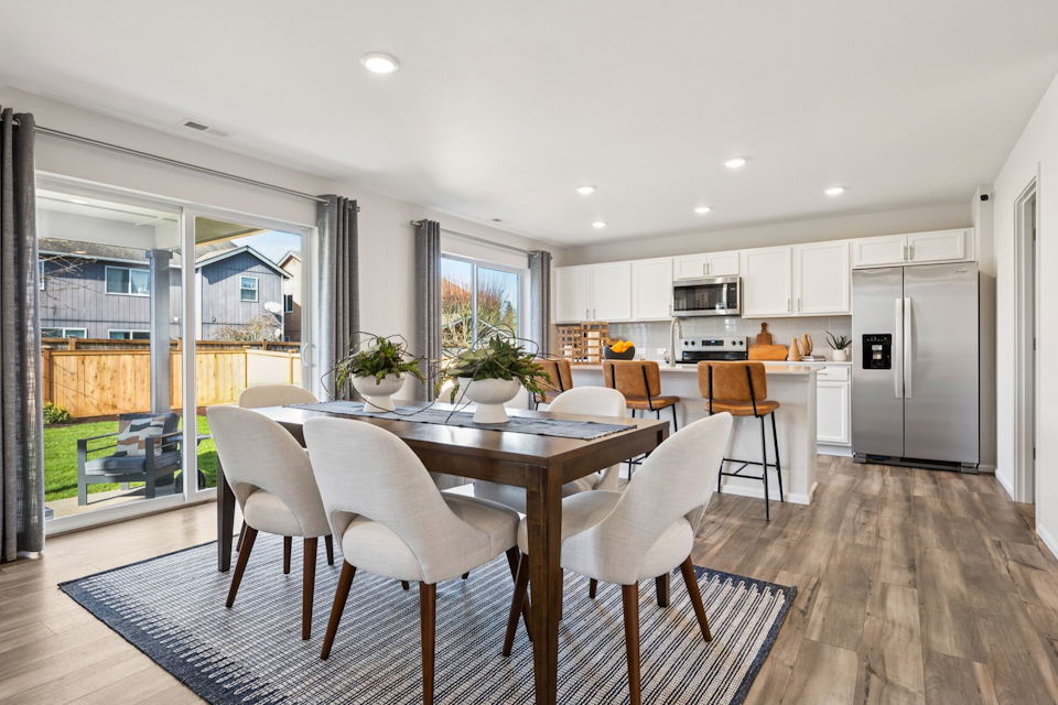 A kitchen with a dining table and chairs.